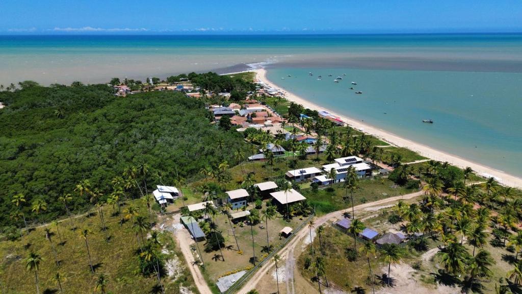 Vista aérea da Ponta do Corumbau mostrando a faixa de areia cercada por coqueiros e o mar calmo na Bahia Vista aérea da Ponta do Corumbau mostrando a faixa de areia cercada por coqueiros e o mar calmo na Bahia