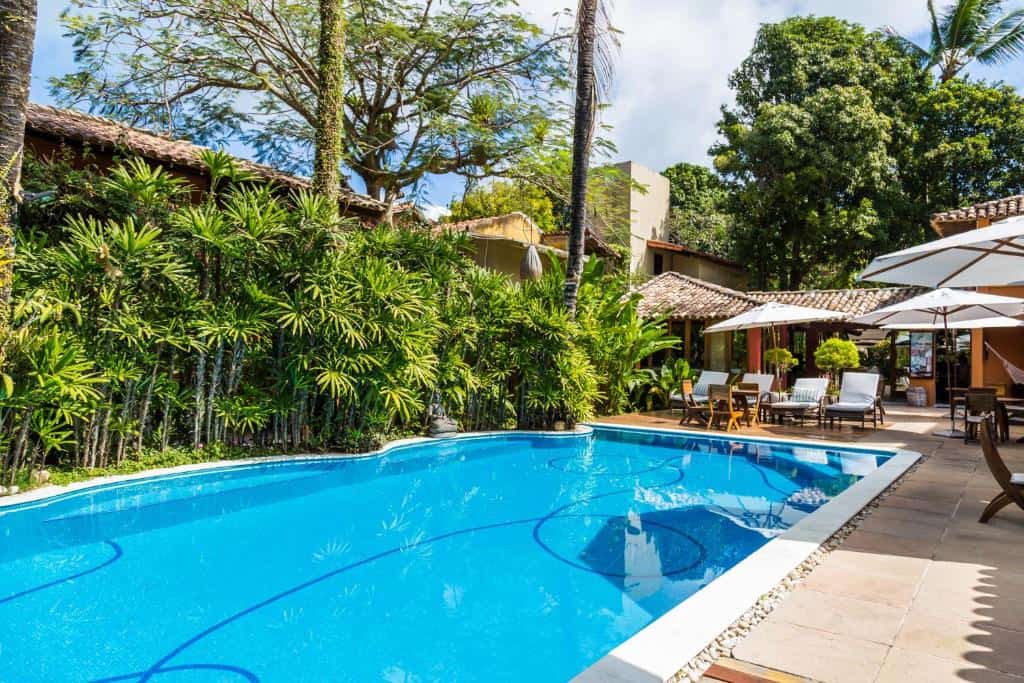 Piscina cercada por jardins tropicais no Hotel Pousada Coqueiros, na Alameda dos Flamboyants em Arraial d'Ajuda Piscina cercada por jardins tropicais no Hotel Pousada Coqueiros, na Alameda dos Flamboyants em Arraial d'Ajuda