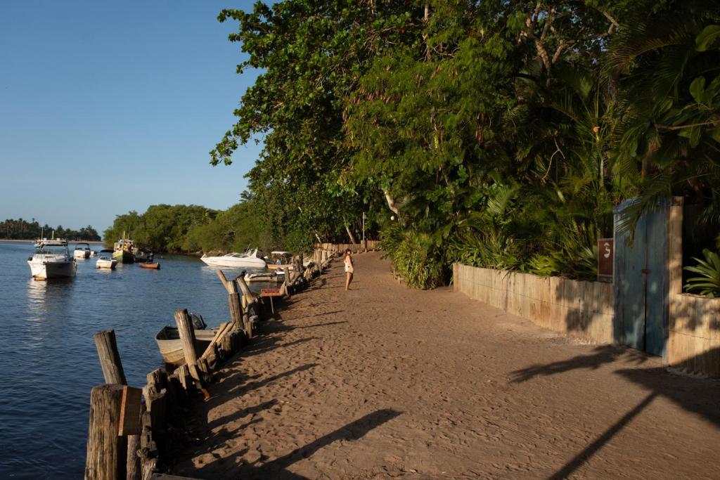 Rua de areia na Beira do Rio em Caraíva, com o Rio Caraíva e canoas Rua de areia na Beira do Rio em Caraíva, com o Rio Caraíva e canoas
