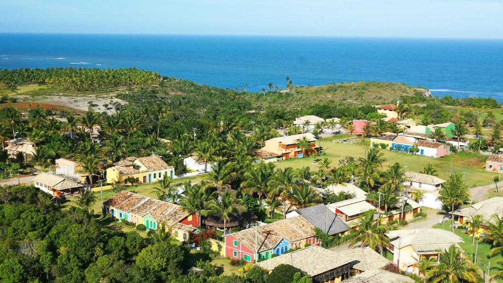 Vista aérea das casas coloridas e gramados do Condomínio Outeiro das Brisas no alto da falésia da Praia do Espelho. Vista aérea das casas coloridas e gramados do Condomínio Outeiro das Brisas no alto da falésia da Praia do Espelho.