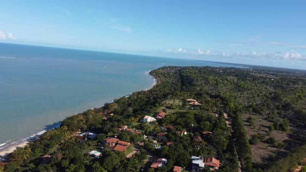 Vista aérea da faixa de areia sombreada e das pousadas horizontais na Praia do Rio do Peixe, em Cumuruxatiba Vista aérea da faixa de areia sombreada e das pousadas horizontais na Praia do Rio do Peixe, em Cumuruxatiba