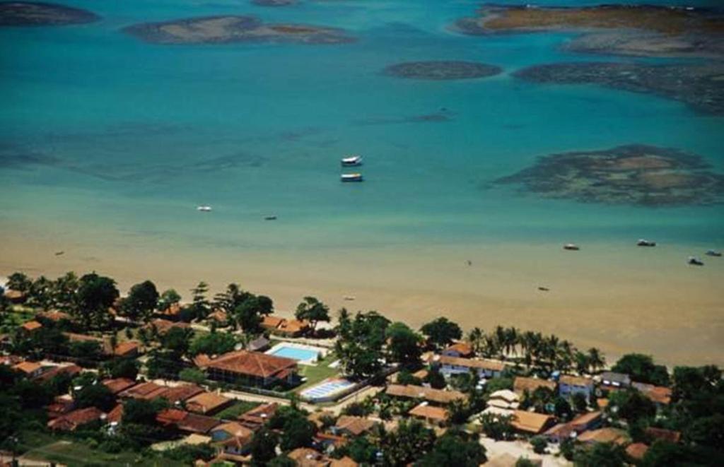 Vista aérea da orla central da Vila de Cumuruxatiba, destacando a faixa de areia e a proximidade das pousadas com o mar no distrito de Prado, Bahia Vista aérea da orla central da Vila de Cumuruxatiba, destacando a faixa de areia e a proximidade das pousadas com o mar no distrito de Prado, Bahia
