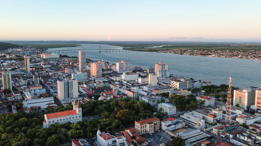 Centro Histórico de Aracaju às margens do Rio Sergipe Vista aérea panorâmica do Centro Histórico de Aracaju às margens do Rio Sergipe, mostrando o traçado urbano e a ponte que liga à Barra dos Coqueiros ao fundo.