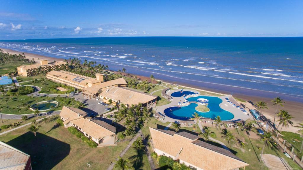 Makai Resort All Inclusive Aracaju - Barra dos Coqueiros Foto aérea do complexo hoteleiro pé na areia do Makai Resort All Inclusive na Barra dos Coqueiros em Aracaju destacando o desenho sinuoso da piscina azul e a proximidade com o mar