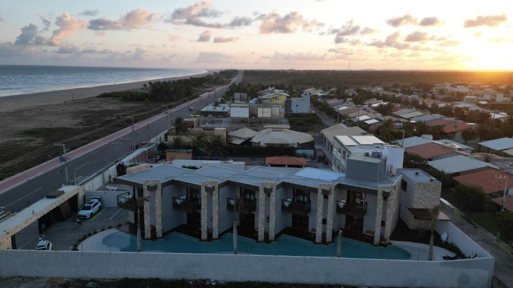 Villa Prime Beach Flats - Praia do Mosqueiro - Aracaju Vista aérea dos blocos modernos do Villa Prime Beach Flats na Praia do Mosqueiro em Aracaju mostrando a piscina no pátio interno e a avenida beira-mar ao entardecer