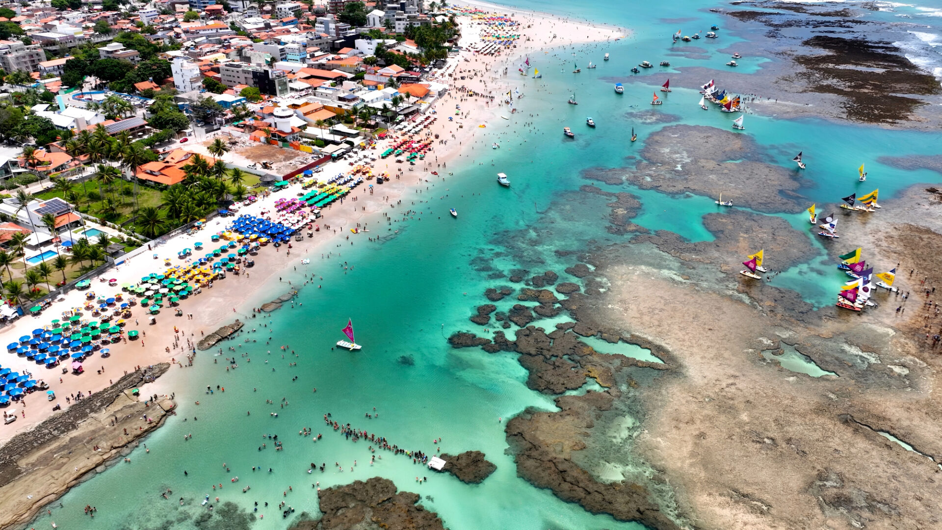 Praia de Porto de Galinhas - Pernambuco Vista aérea da Vila de Porto de Galinhas, com a Praia de Porto de Galinhas, barracas, piscinas naturais e o centrinho ao fundo.